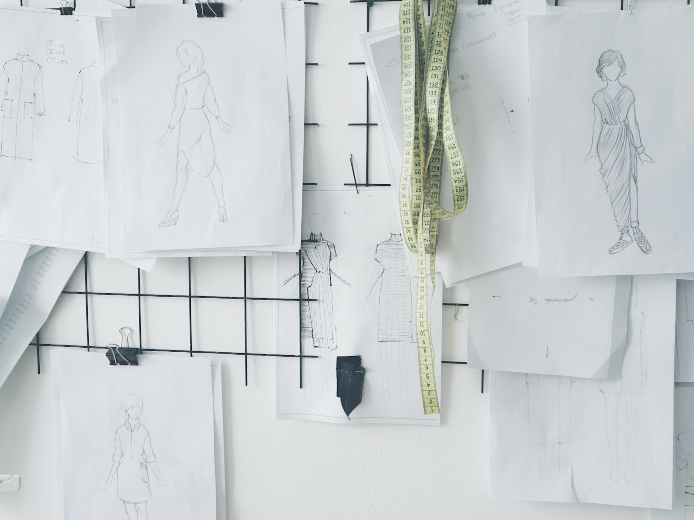 Hands working over sketches and fabric