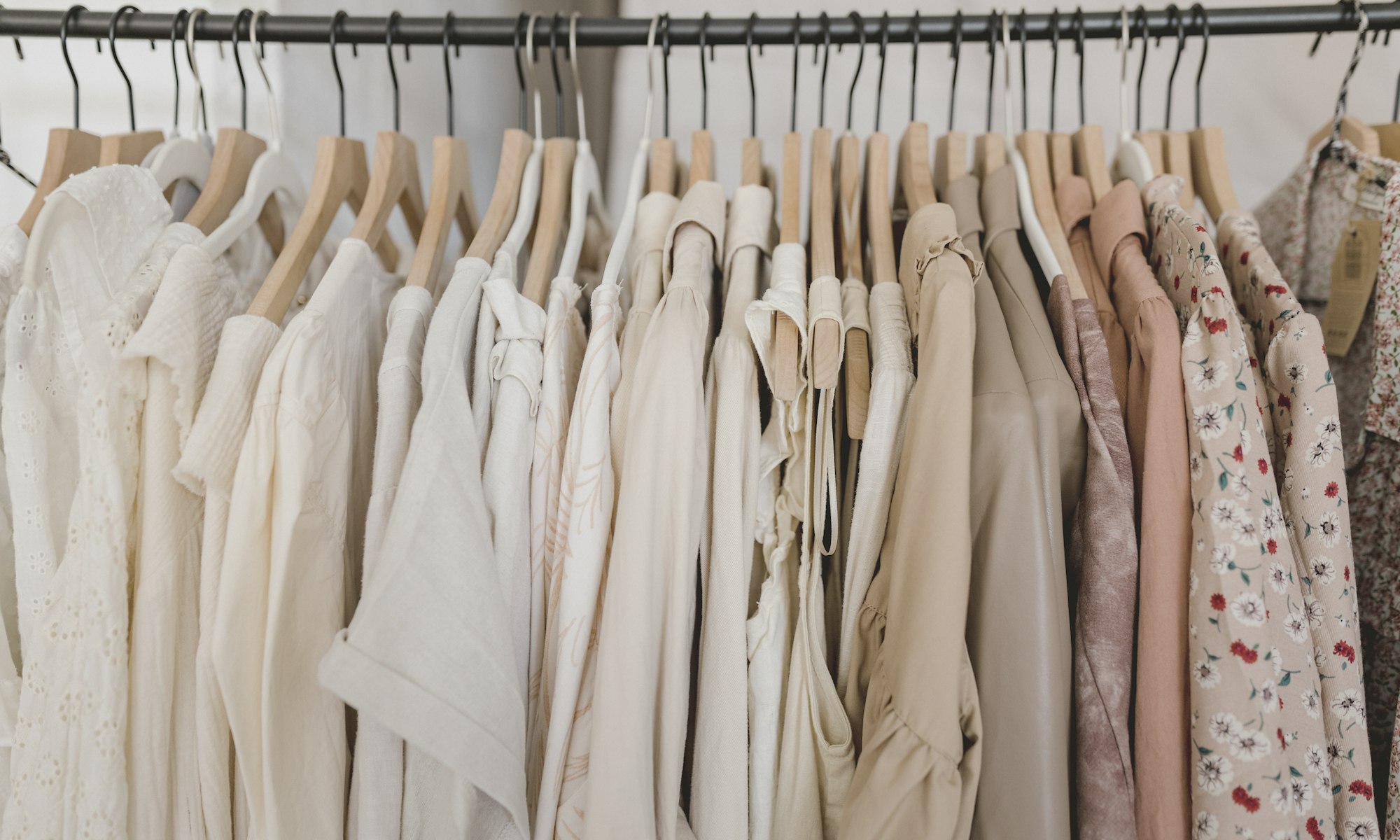 Bomo styling a client beside a rail of garments